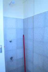 a shower with a red pole in a bathroom at Semo's apartment in Bamburi