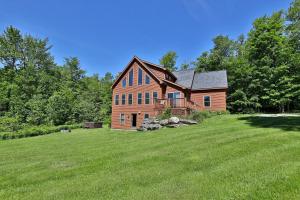 a large house on a grassy field with trees at Cortina Mountain Chalet - Outdoor Hot Tub - Close to Pico and Killington Mountains home in Mendon