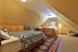 a attic bedroom with a bed and a window at Cortina Mountain Chalet - Outdoor Hot Tub - Close to Pico and Killington Mountains home in Mendon