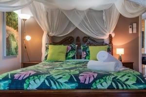 Airlie Getaway - Airlie Beach في شاطئ إيرلي: غرفة نوم بسرير مع مظلة