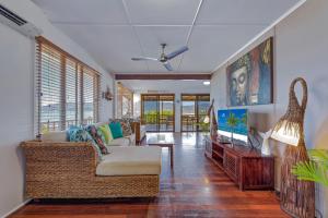 ein Wohnzimmer mit einem Sofa und einem TV in der Unterkunft Airlie Getaway - Airlie Beach in Airlie Beach