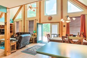 uma sala de estar com uma mesa, cadeiras e janelas em Cloudcroft Home with Spacious Stargazing Deck! em Cloudcroft