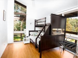 a bedroom with a bunk bed and large windows at Don Valley Lodge in Launching Place