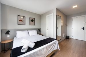 1 dormitorio con 1 cama blanca grande y espejo en MV136B - Encanto nas Proximidades da Estação Brás: Seu Estúdio Acolhedor!, en São Paulo