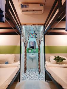 a room with two beds and a bathroom with a sink at Ben Guesthouse Phu Quoc in Phu Quoc