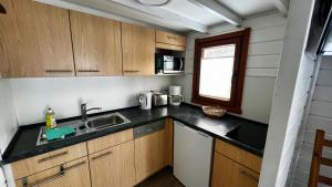 een kleine keuken met houten kasten en een spoelbak bij Ferienhaus Seepferdchen in Göhren