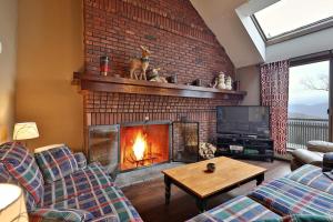 sala de estar con chimenea y TV en Sunrise Timberline- 3BR, 2BA Ski In Ski Out Condo condo, en Killington