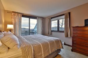1 dormitorio con 1 cama y 2 ventanas en Sunrise Timberline- 3BR, 2BA Ski In Ski Out Condo condo, en Killington