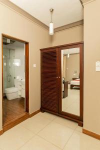 a room with a bathroom with a toilet and a mirror at Kings Ridge Kandy in Kandy