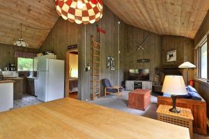 a kitchen and living room with a refrigerator and a table at Left Duplex Home Directly Across From Pico Mountain, Close to Killington, home in Killington