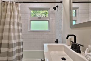 a white bathroom with a sink and a window at Left Duplex Home Directly Across From Pico Mountain, Close to Killington, home in Killington +18 photos