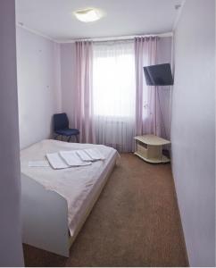 a hotel room with a bed and a window at Motel in Ivano-Frankivsʼk