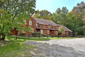 una gran casa de ladrillo con una valla delante de ella en Glazebrook by Killington Vacation Rentals, en Killington