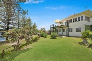 a large white house with a fence and a yard at 35 Wilson Avenue Dicky Beach QLD in Caloundra