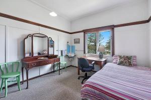 a bedroom with a bed and a desk and a desk at 35 Wilson Avenue Dicky Beach QLD in Caloundra