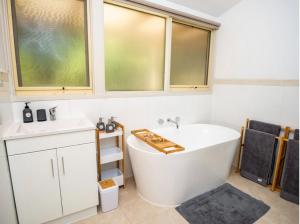 a bathroom with a large white tub and two windows at Don Valley Lodge in Launching Place