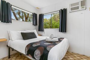 een slaapkamer met een bed en 2 ramen bij BIG4 Breeze Holiday Parks - Port Elliot in Port Elliot