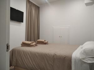 um quarto com uma cama com toalhas em El PORTON DE LA BELLOTA - CON PARKING GRATIS - EN EL CENTRO DE TOLEDO em Toledo