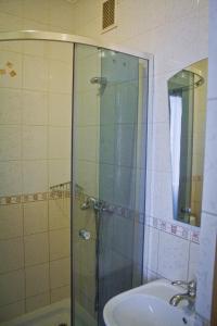 y baño con ducha acristalada y lavamanos. en Motel, en Ivano-Frankivsk