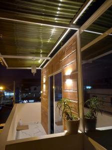 una habitación con 2 macetas en un balcón por la noche en DEPARTAMENTO-MANTA, Playa Murciélago, en Manta