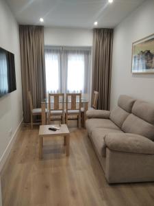 sala de estar con sofá y mesa en El PORTON DE LA BELLOTA - CON PARKING GRATIS - EN EL CENTRO DE TOLEDO, en Toledo