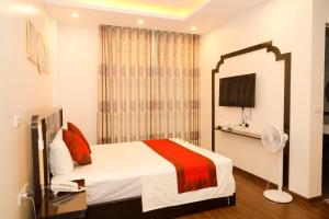 a hotel room with a bed and a mirror at Hoàng Tử Hotel in HÆ°ng YÃªn
