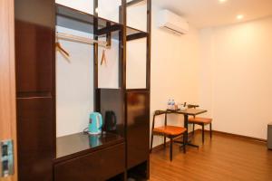 a room with a desk and a table with chairs at Hoàng Tử Hotel in HÆ°ng YÃªn