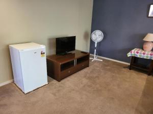 a room with a refrigerator and a tv and a chair at Lucky House in Point Cook