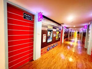 a corridor of a building with red doors and wooden floors at 柜富賓王旅店-台北館 Giant Rich King Plaza Hotel in Taipei