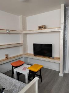 Habitación con 2 sillas, mesa y TV. en Logroño Centro Home, en Logroño