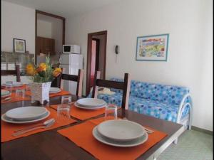 jadalnia ze stołem z talerzami w obiekcie Cozy family escape - Beahost w Bibione