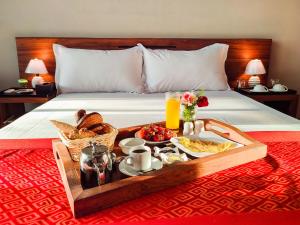 a tray of food on a bed with a breakfast at Valiha Hotel Antananarivo in Antananarivo