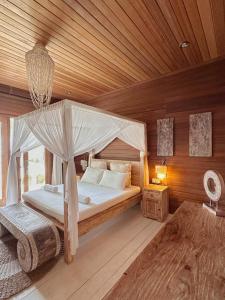 a bedroom with a canopy bed and a wooden ceiling at Met House in Thulusdhoo