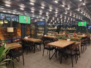 a restaurant with wooden tables and chairs and a tv at Kuhla Hotel in Trabzon