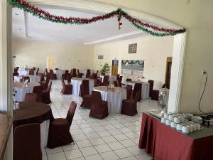 a banquet hall with tables and chairs and christmas decorations at Hotel Puspa Sari in Ciater