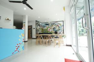 a dining room with a large mural on the wall at Bedbox Hostel in Patong Beach