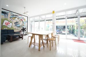 a dining room with a table and some chairs at Bedbox Hostel in Patong Beach