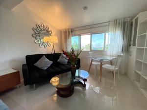 a living room with a black couch and a table at Elluk East Studios in Port Vila
