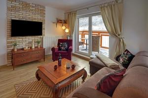- un salon avec un canapé et une table basse dans l'établissement Trevilles Apartamenty - Orzechowy, à Szklarska Poręba