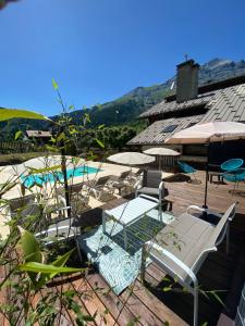 un patio con tavolo, sedie e piscina di Hotel Le Christiania a Les Contamines-Montjoie