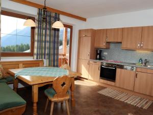 eine Küche mit einem Tisch und einem Esszimmer in der Unterkunft Apartments Filzsteinalm, Hochkrimml in Kirchdorf