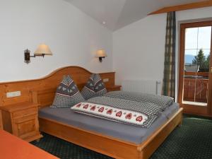 ein Schlafzimmer mit einem Holzbett mit Kissen darauf in der Unterkunft Apartments Filzsteinalm, Hochkrimml in Kirchdorf