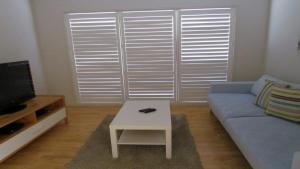 a living room with a blue couch and a table at 77 Roderick St Moffat Beach QLD in Caloundra