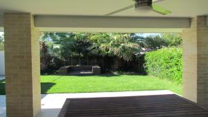 a screened in porch with a view of a yard at 77 Roderick St Moffat Beach QLD in Caloundra