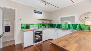 a kitchen with white cabinets and a clock on the wall at 92 Landsborough Parade Golden Beach in Golden Beach +2 photos