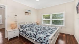 a white bedroom with a bed and a window at 92 Landsborough Parade Golden Beach in Golden Beach