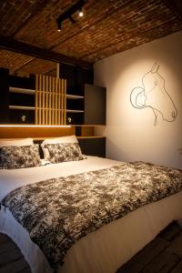 Un dormitorio con una cama y una pared con un caballo. en Le Relais de la Posterie, en Gembloux