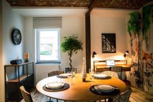 a dining room with a wooden table and chairs at Le Relais de la Posterie in Gembloux