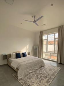 a bedroom with a bed and a ceiling fan at Bait Al Budoor rest house in Al Raka