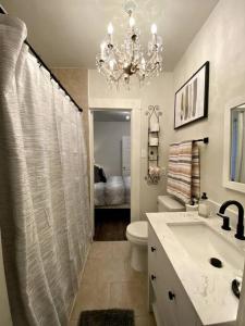 ein Badezimmer mit einem Kronleuchter, einem WC und einem Waschbecken in der Unterkunft Kentucky Kiss on Scenic Drive in El Paso